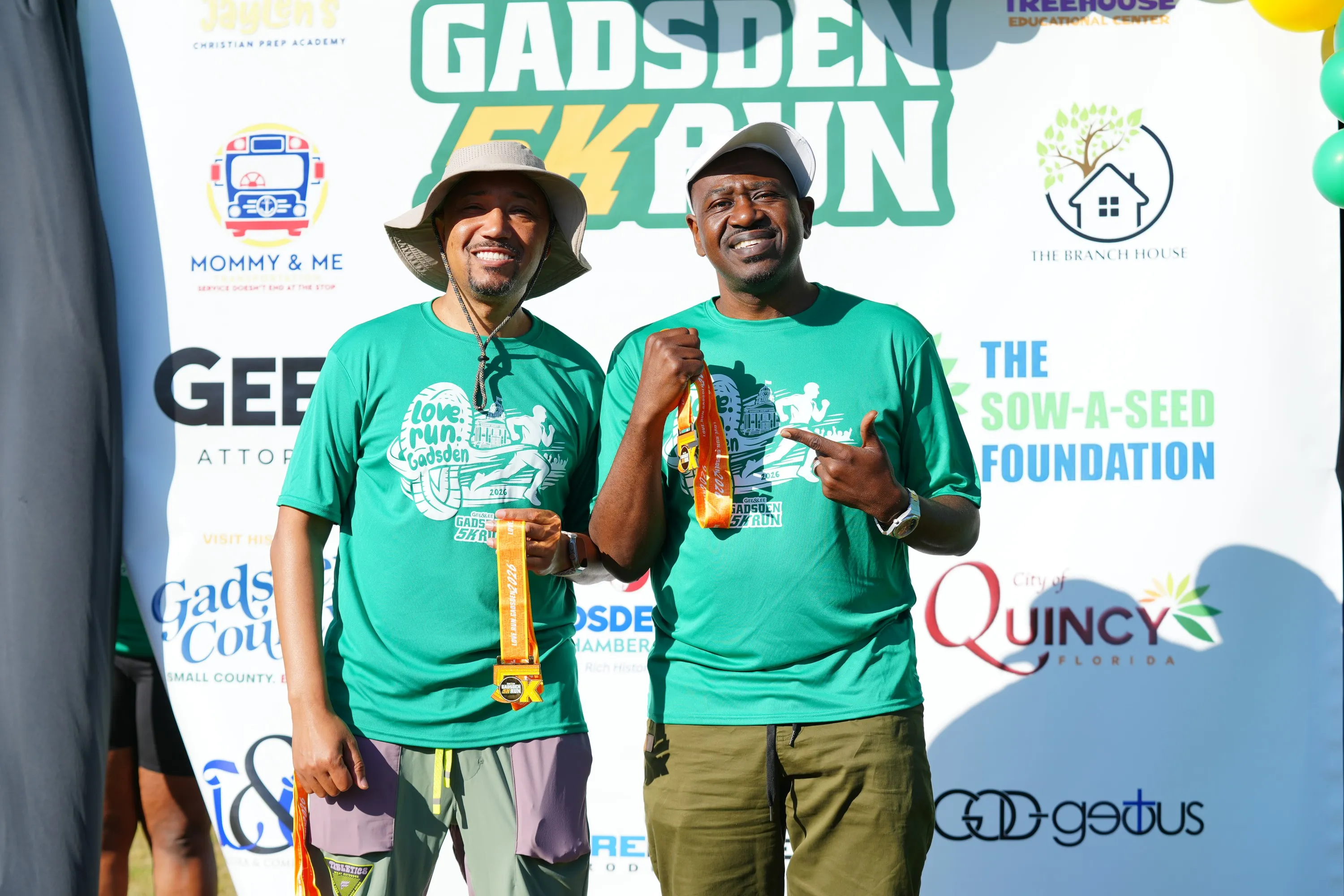 Attorneys Gee and Lee holding finisher medals at the Gadsden 5K Run