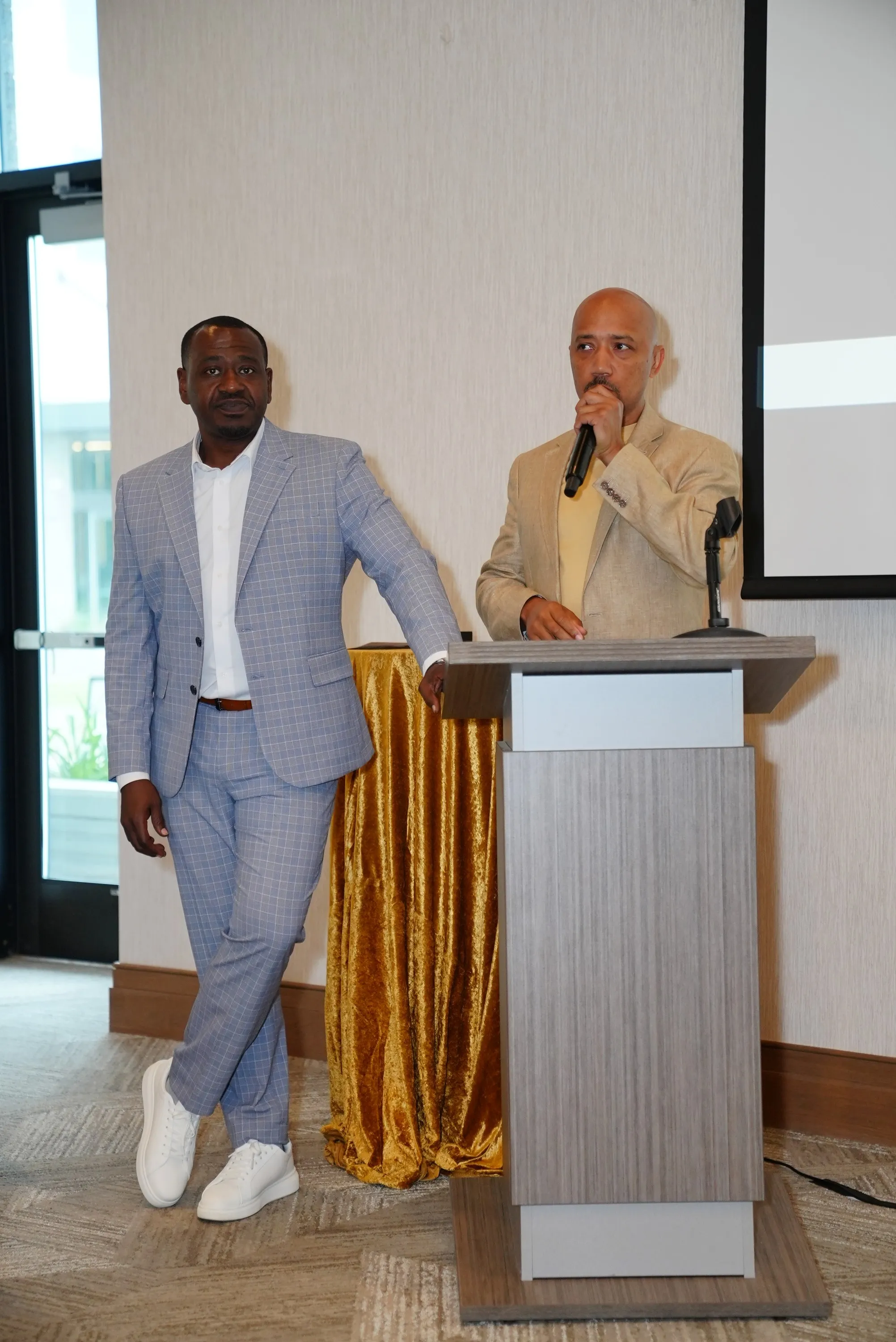 Attorney Gee speaking at a podium alongside attorney Lee at a recognition event
